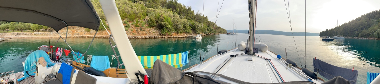 Yacht at anchor in Nedomisje, Cres, with distant views of the Adriatic coastline
