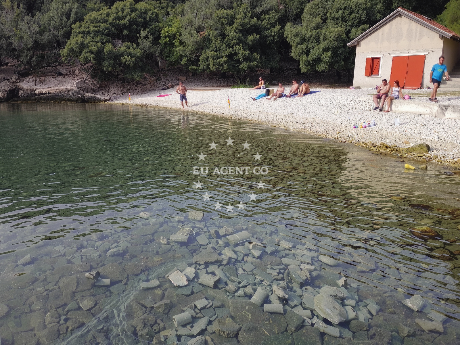 Uvala Krusija beach on Plavnik Island, Croatia with clear waters and rocky shoreline
