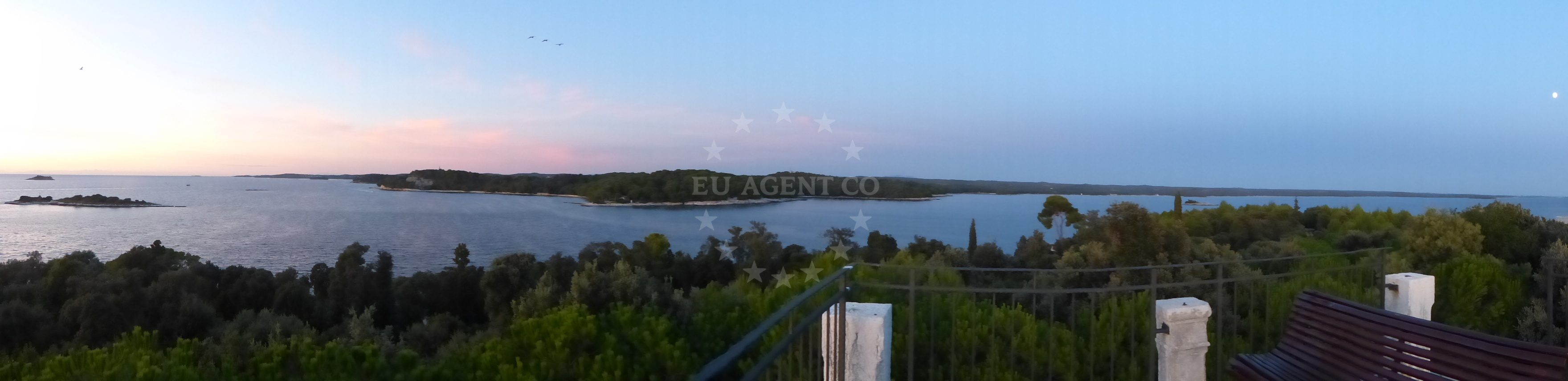 Boat anchored in Sveti Andrija with distant view of Rovinj coastline