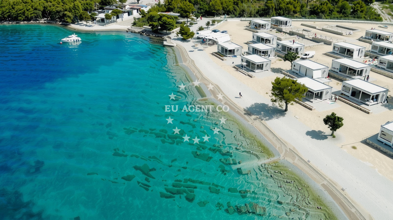 Beach near Drage, North Dalmatia. Sunny shoreline with boats anchored in the background.