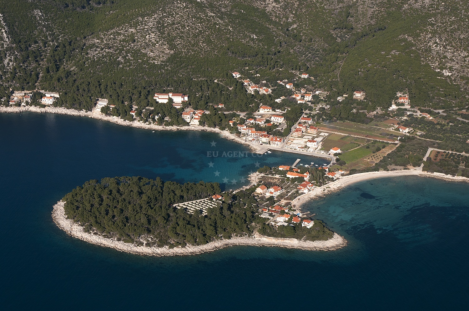 Anchorage in Prizba, Korcula with stone seabed and nearby coastal village