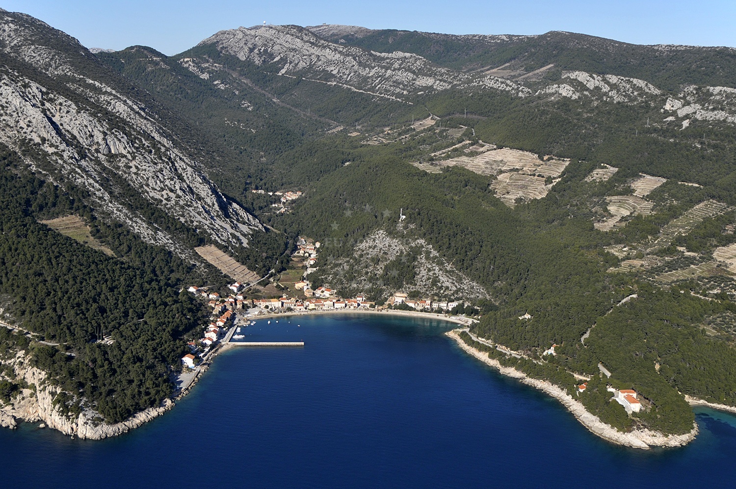 Trstenik Anchorage with yachts moored in calm waters, surrounded by coastal scenery