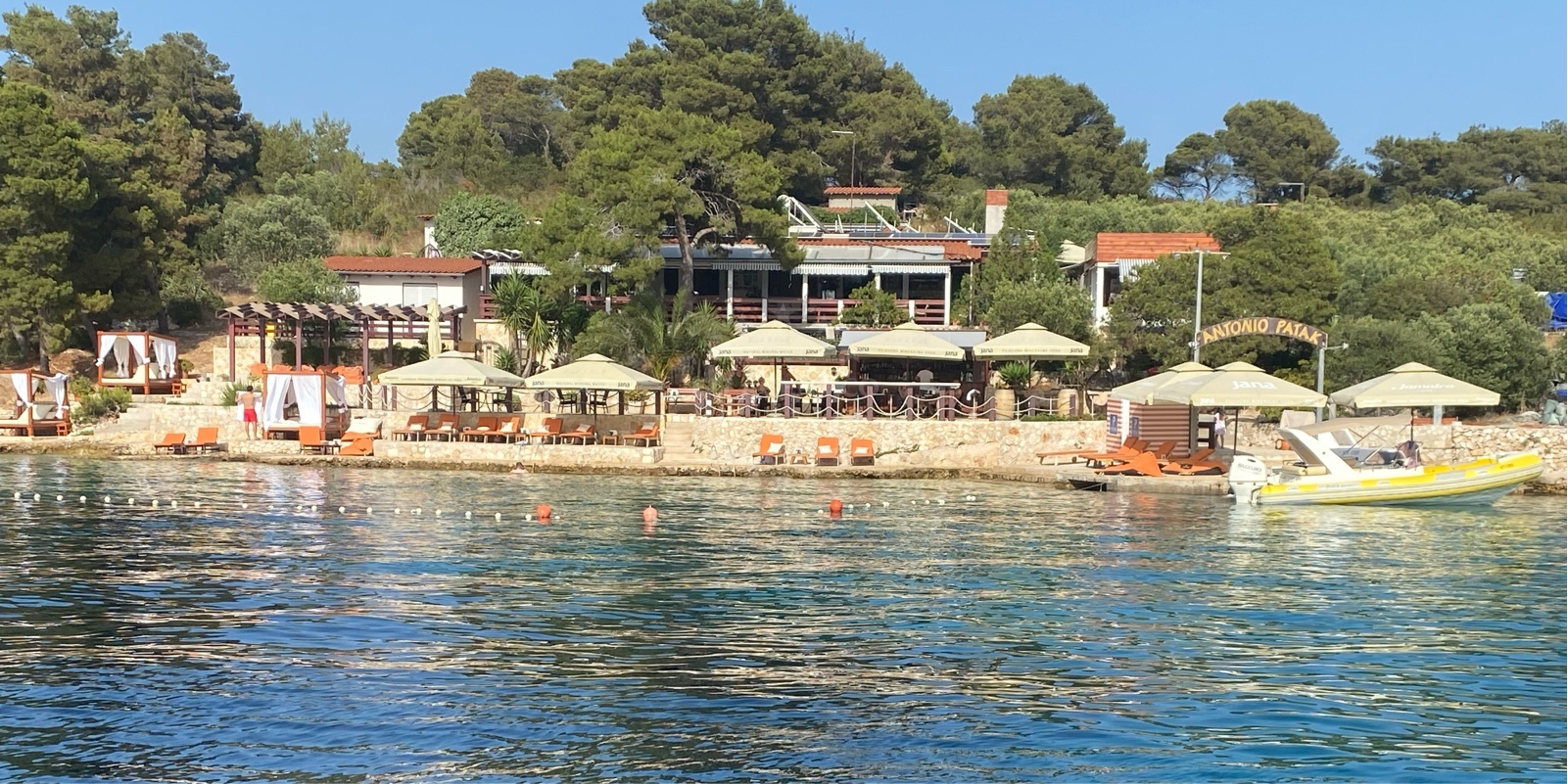 Quay on Marinkovac Island, Central Dalmatia, Croatia with shallow water and nearby restaurant buoys