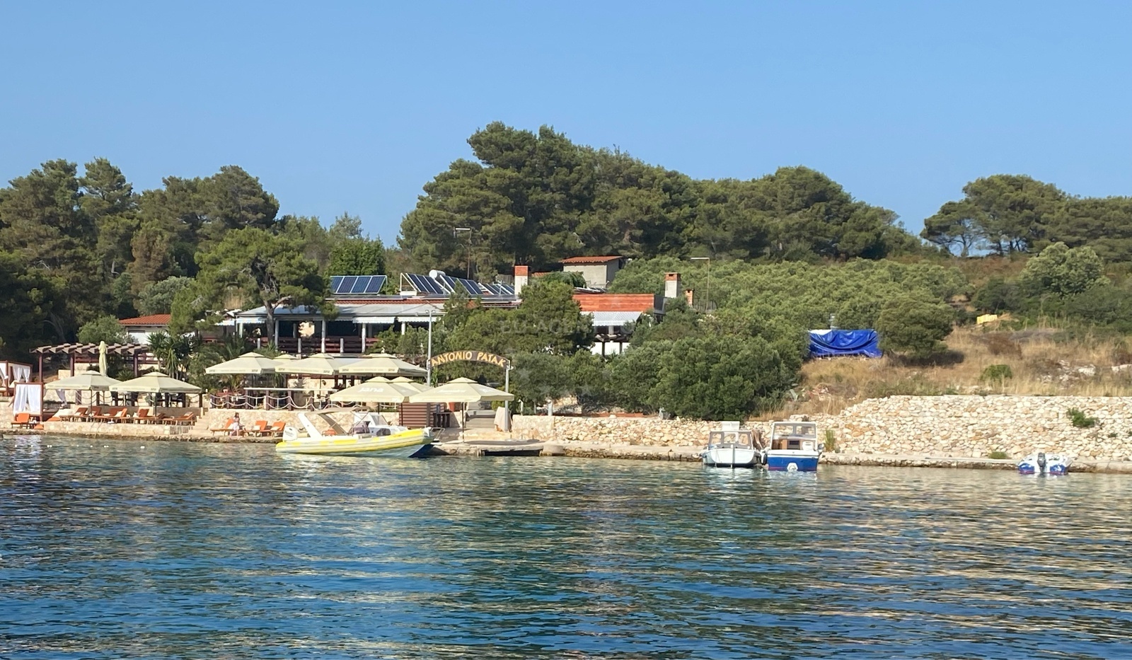 View of quay structure on Marinkovac Island with boats moored near Antonio Patak Restaurant