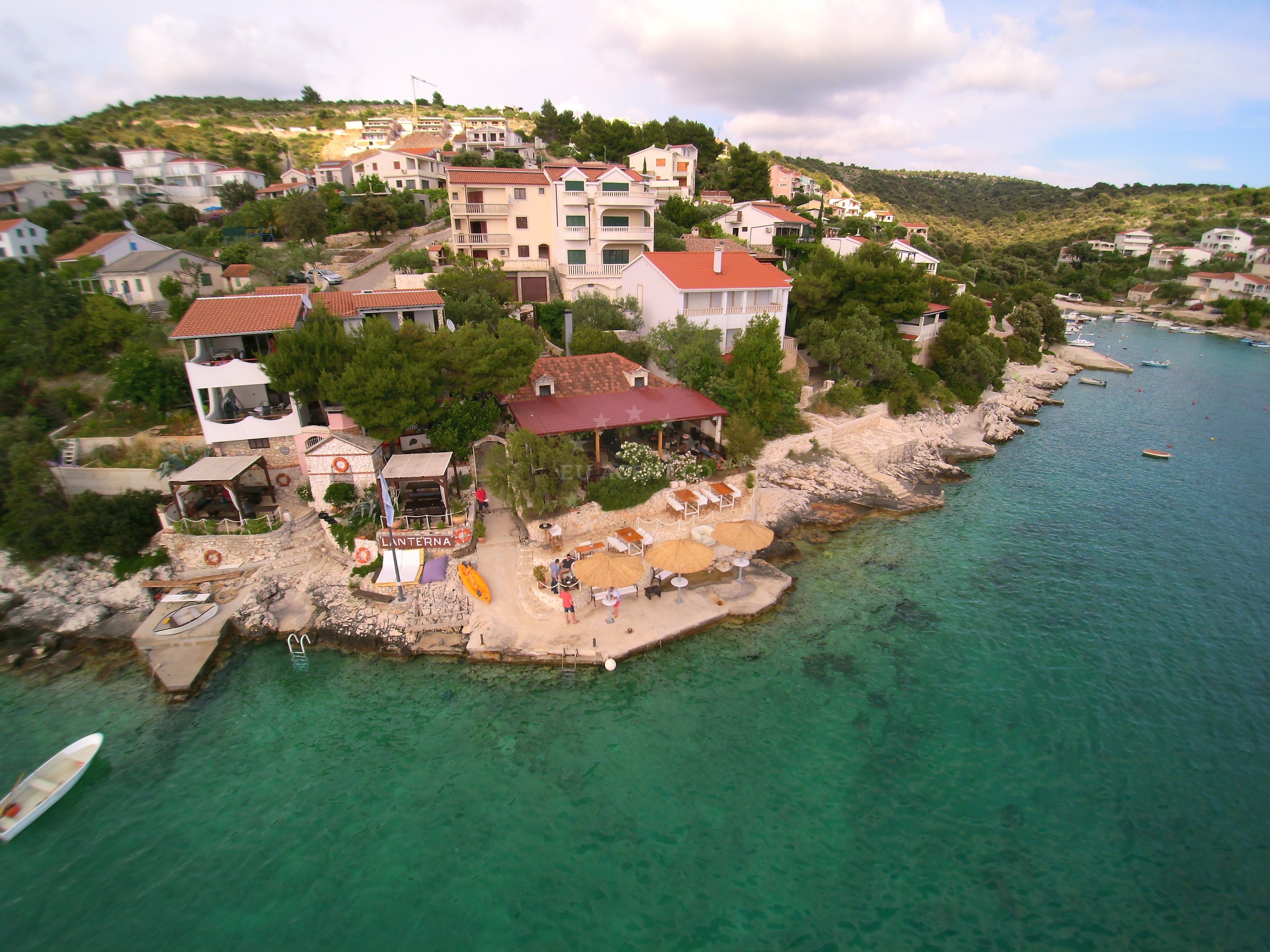 Konoba Lanterna Quay in Sevid, Croatia with mooring lines and the restaurant in the background