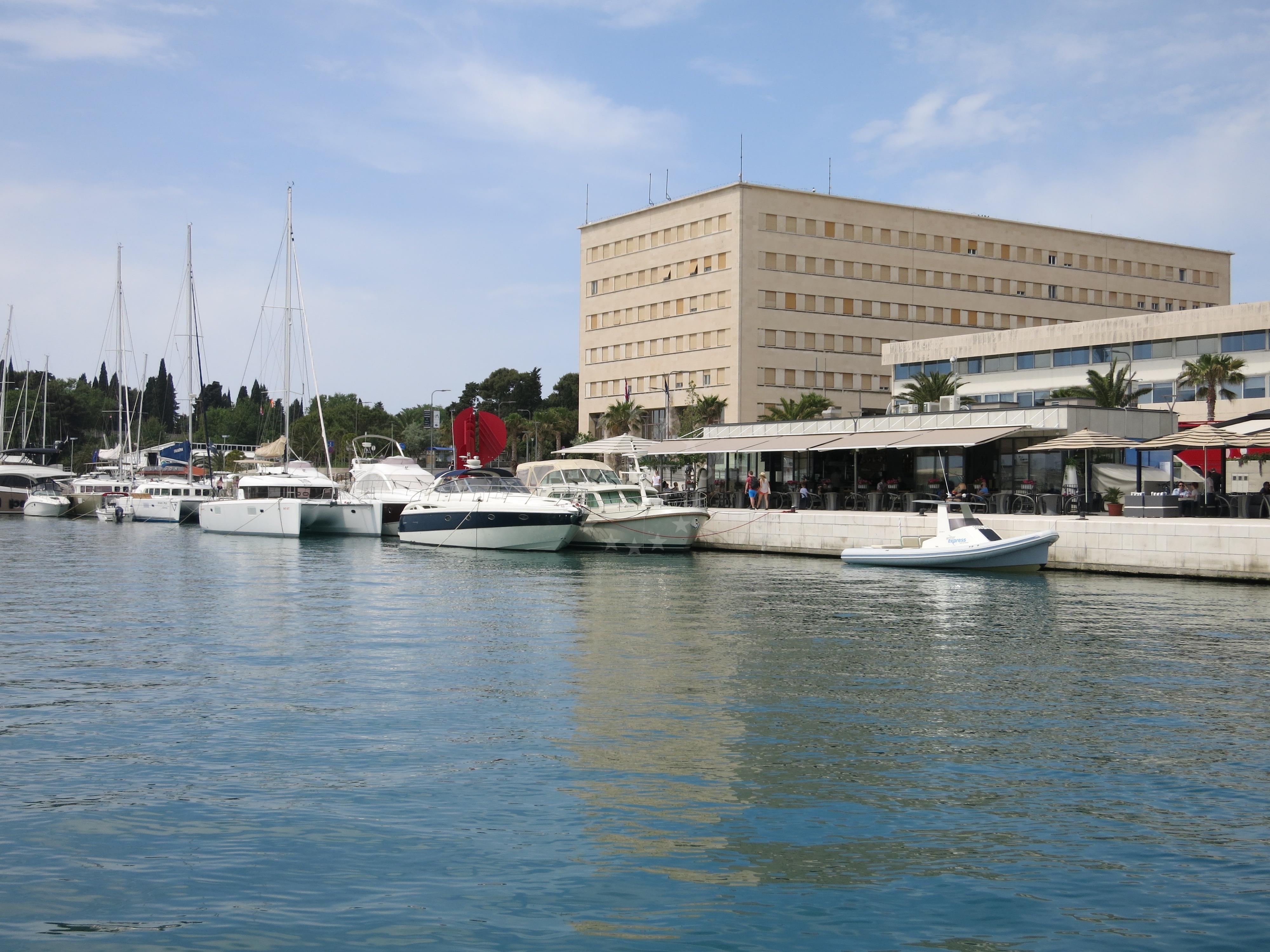 Sailboat moored at Promenade quay with Split's historic buildings visible in the distance