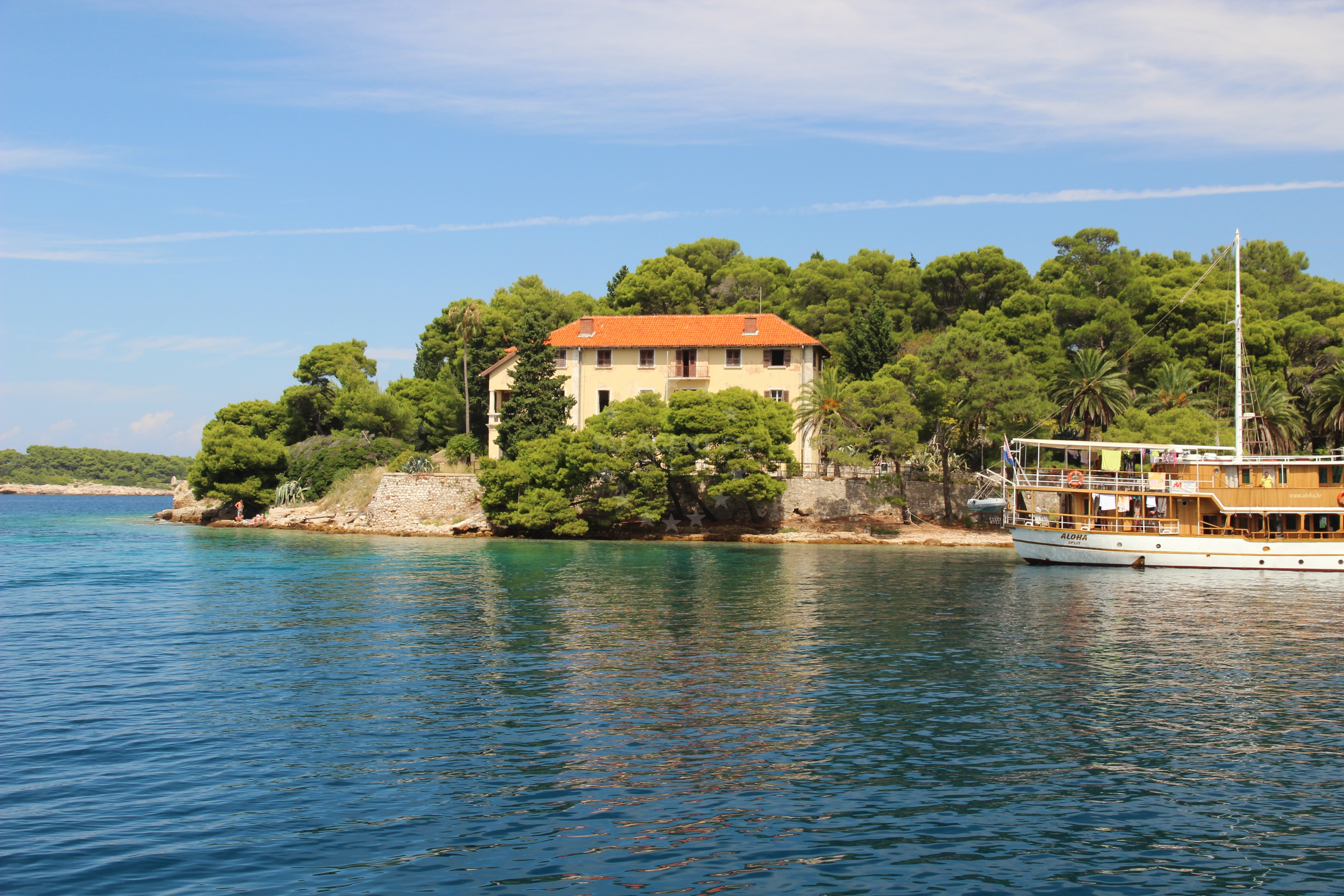 Concrete jetty in Vis, Croatia with an old villa in the background