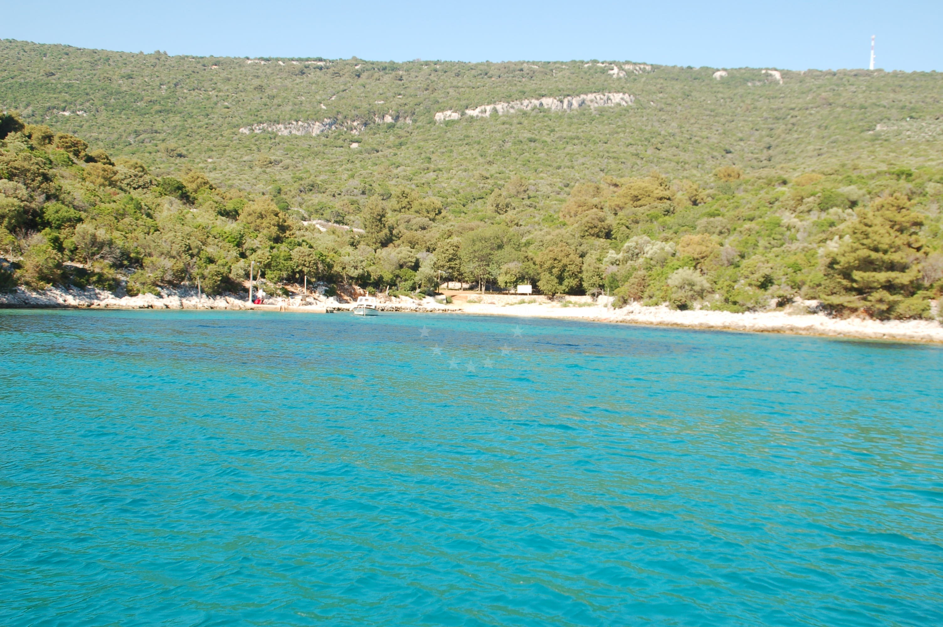 Jetty in Veli Losinj, Croatia, with small boats moored nearby and views of the Adriatic Sea