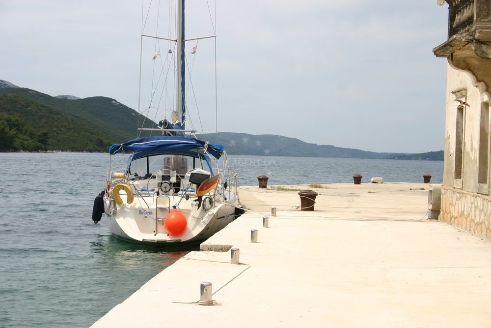 View of Luka Quay from the shore, showing nearby beaches and boats