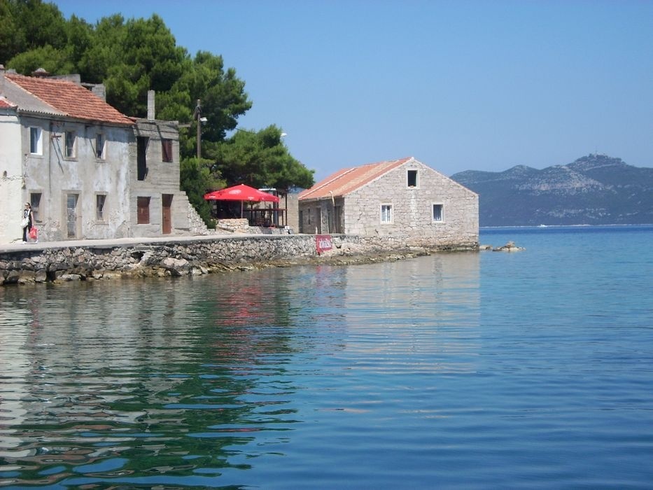 Jetty in Iz Mali, North Dalmatia, Croatia with moored ferry and western outer pier