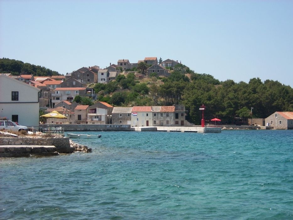 Northern pier of Iz Mali jetty, North Dalmatia, Croatia with nearby boat traffic