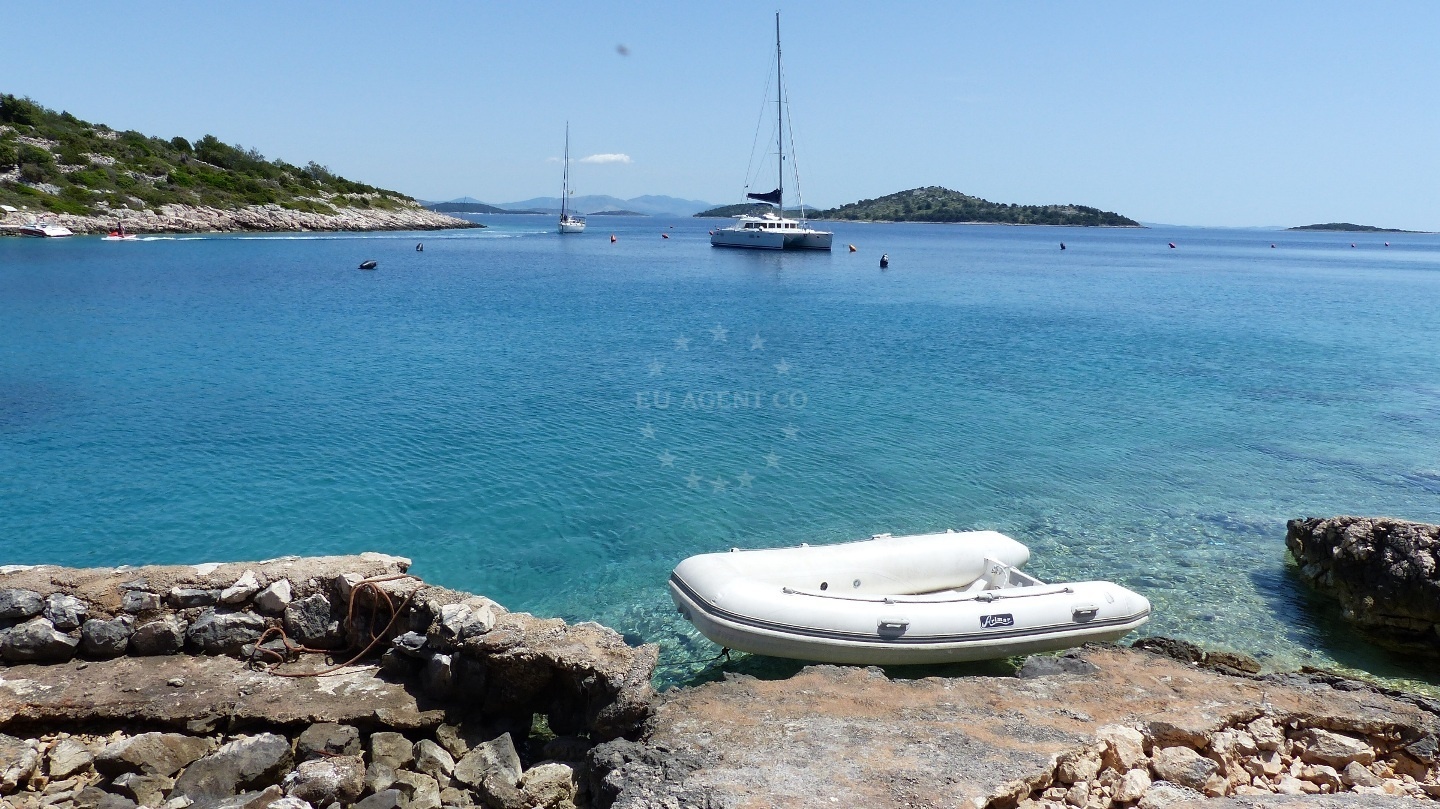 Sailboat approaching Konoba G8 buoys in Kaprije's sheltered bay