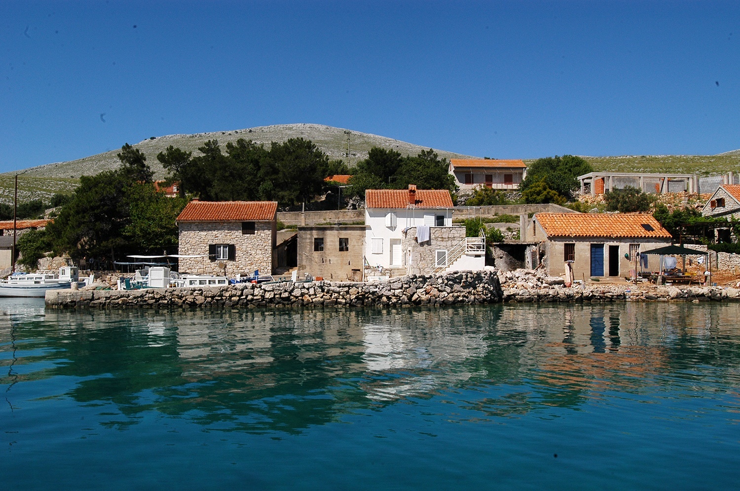 Jetty in Kravljacica, Kornat, North Dalmatia, Croatia with mooring lines and nearby Kravljacica Bay