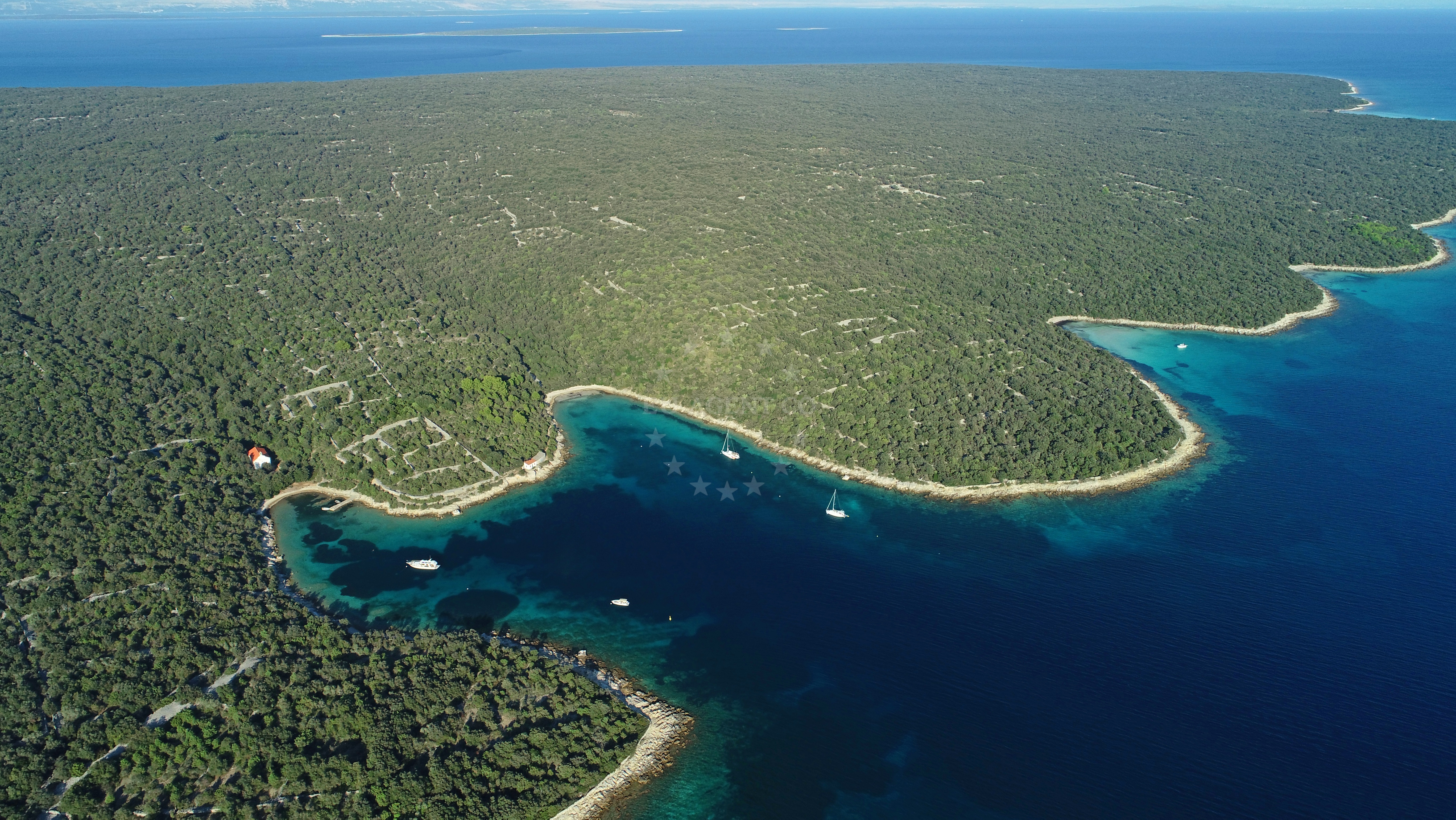 Sv. Nikola buoy field with clear waters and greenery-covered shores