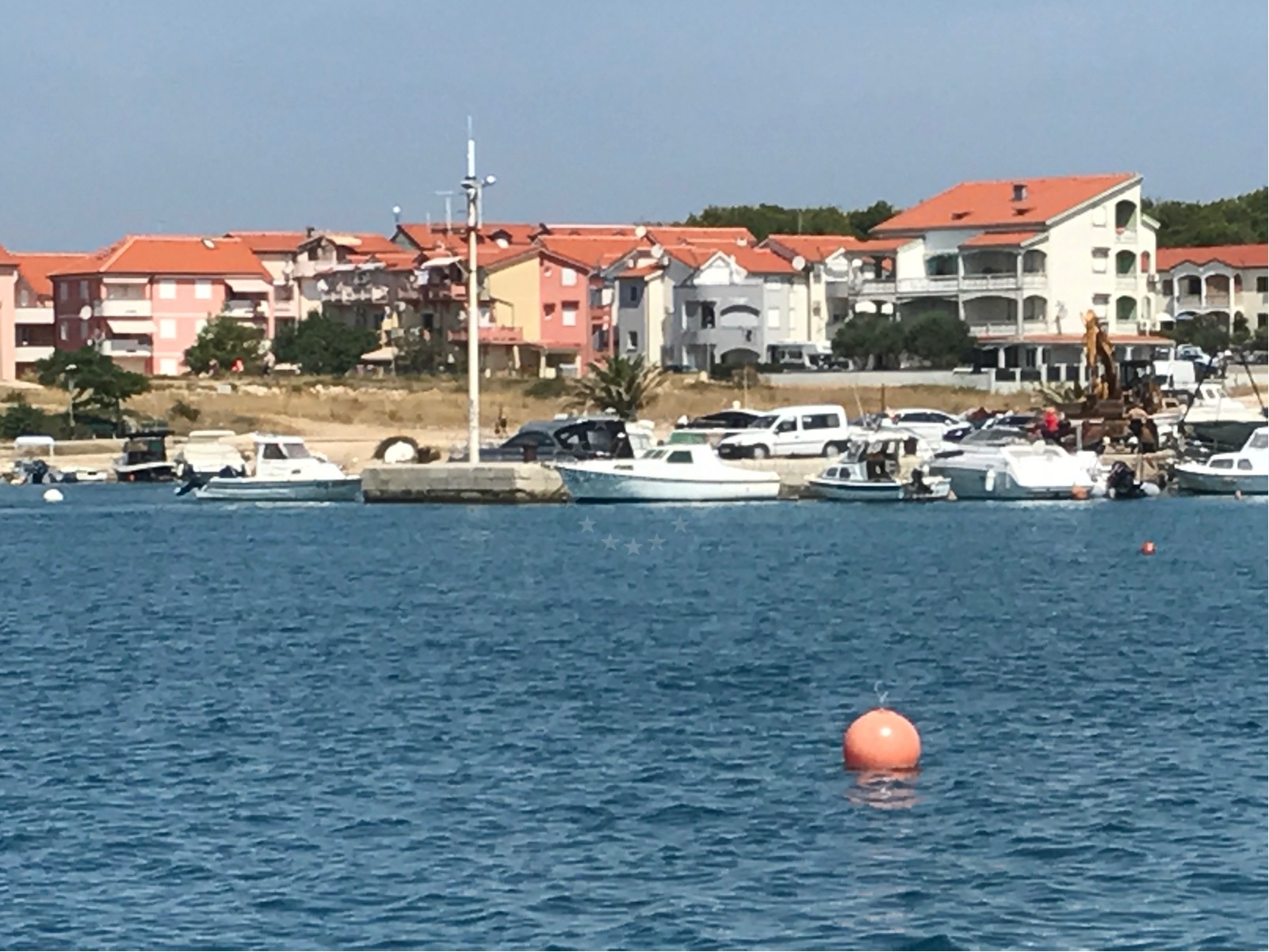 Sibuljina Point jetty with wooded shoreline and bell tower in the distance, North Dalmatia, Croatia