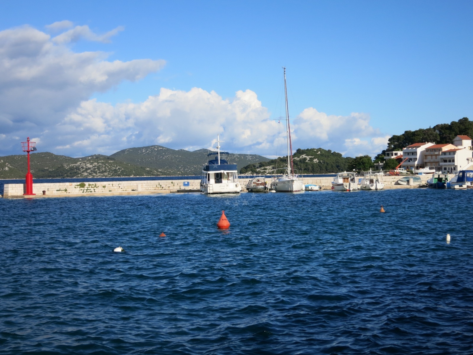 Tranquil harbor at Tisno jetty with yachts docked and protected from northern winds