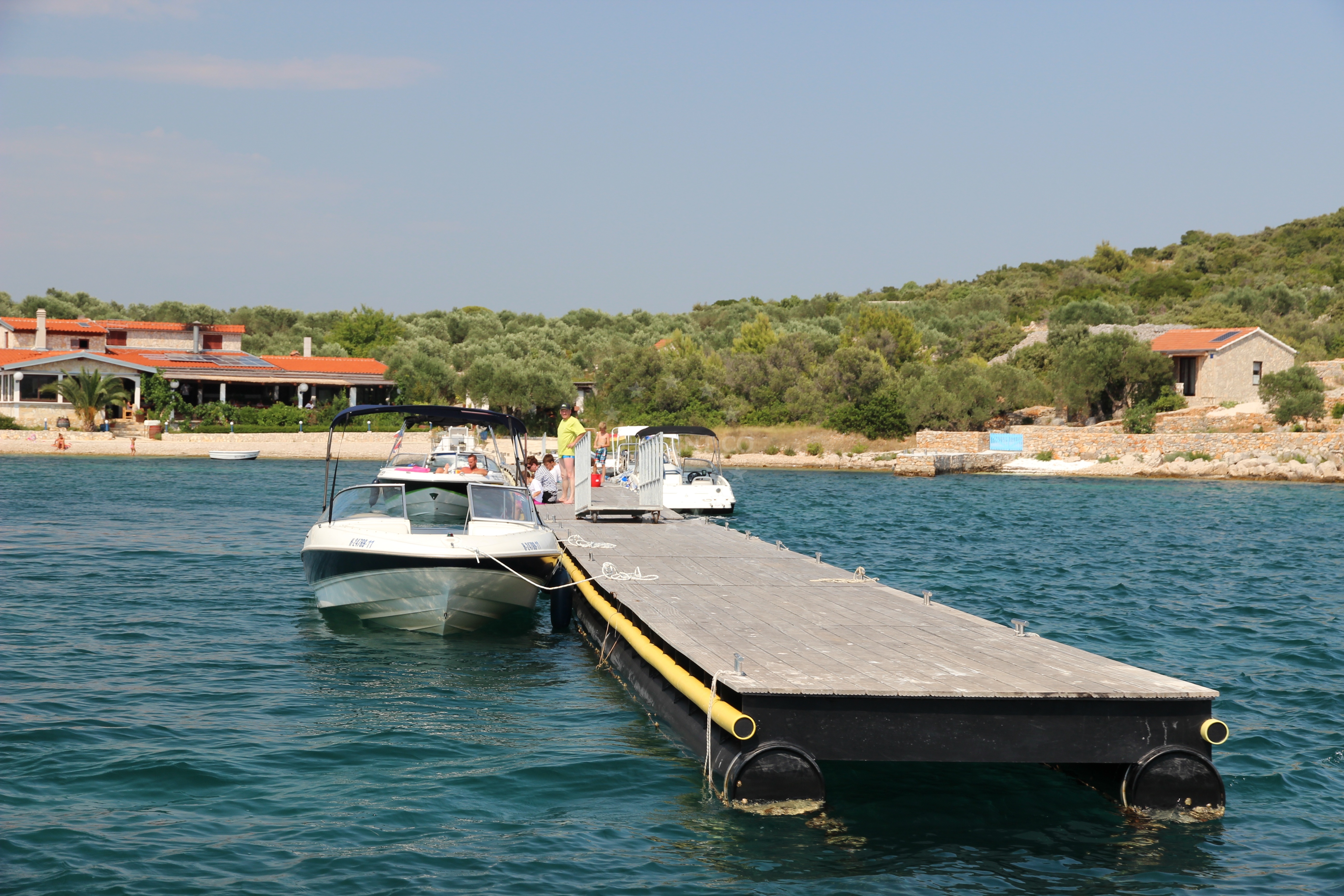 Yacht moored at Konoba Zminjak Jetty with restaurant in the distance