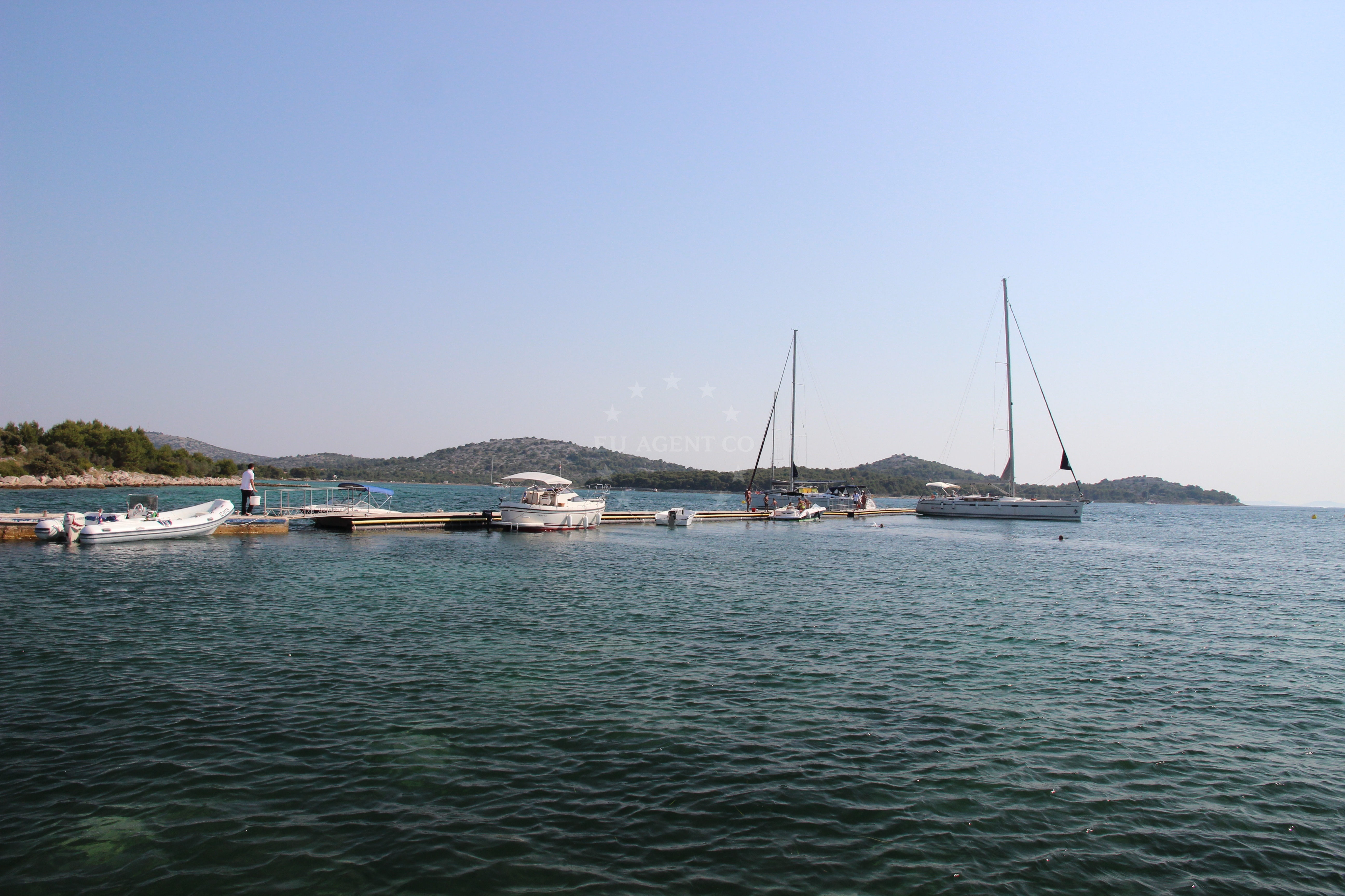 Mooring buoys at Konoba Zminjak Jetty with restaurant signage