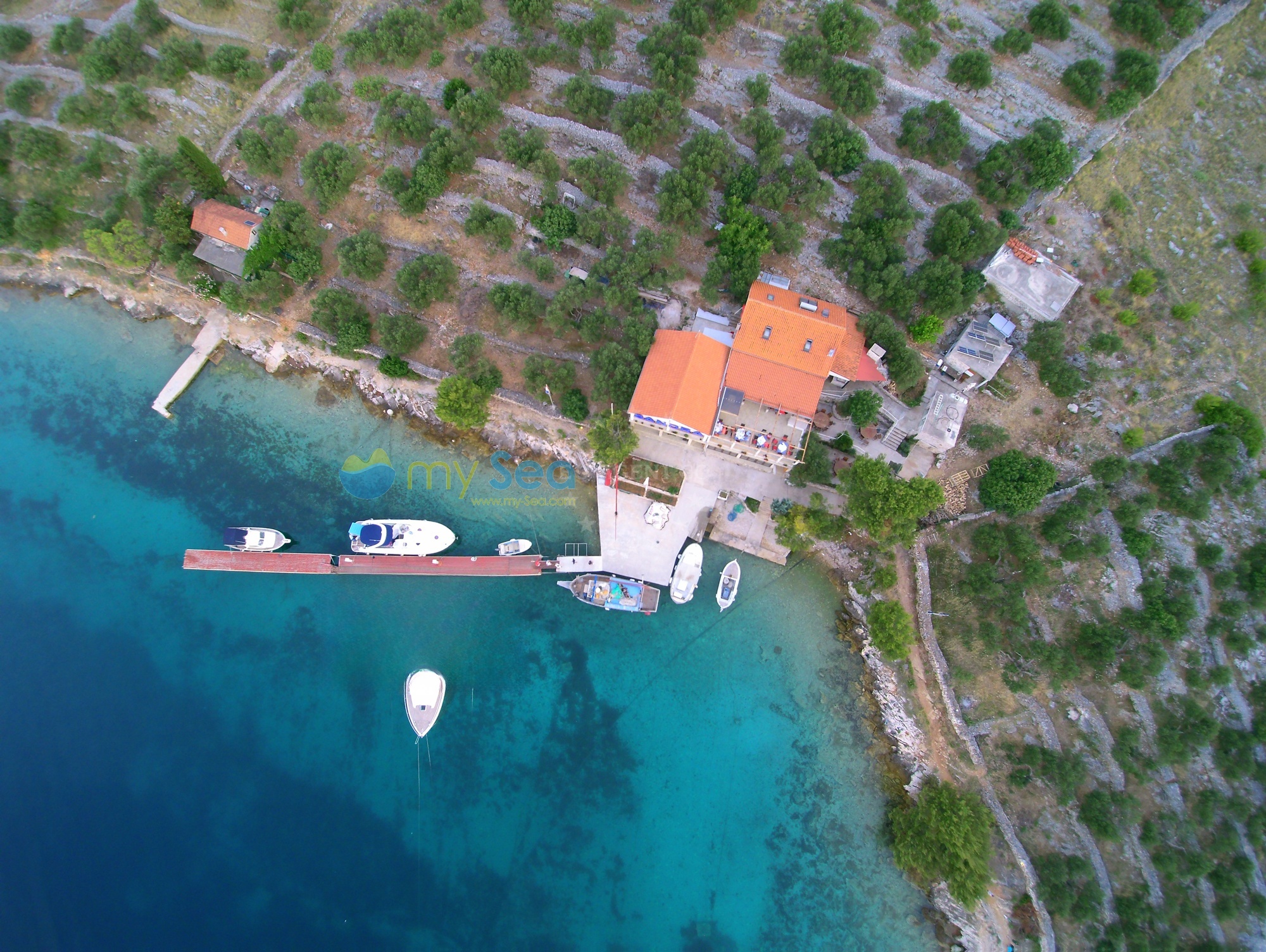 Konoba Sandra Jetty with moored yachts and restaurant terrace overlooking the bay