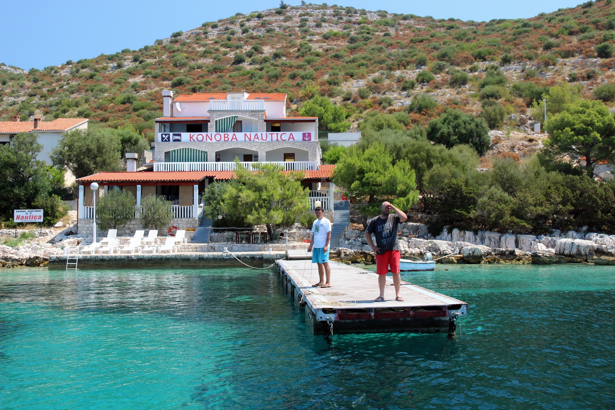 Boats moored at Lastovo Jetty with the island’s cliffs in the background