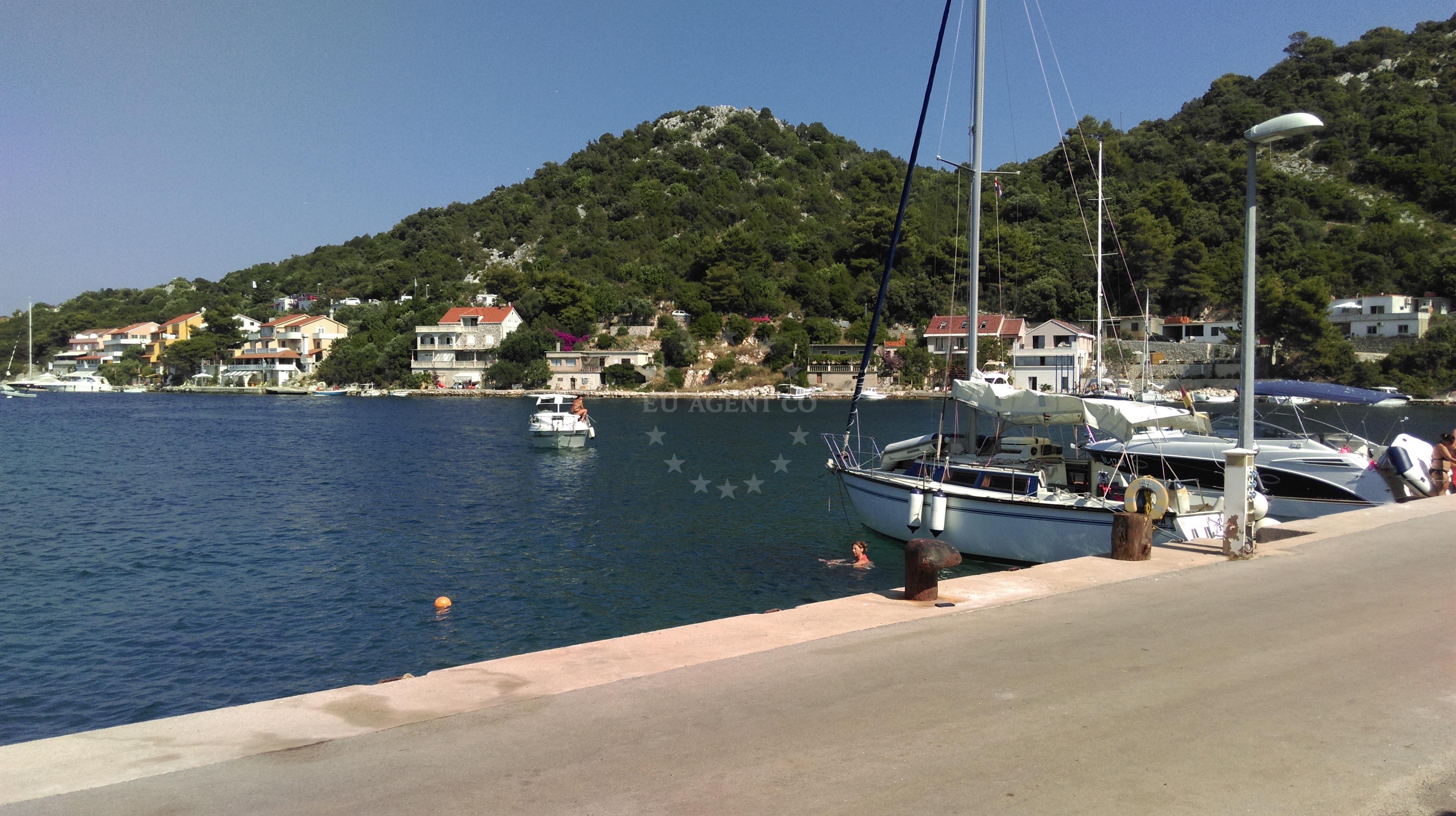 Public quay on Lastovo Island with mooring lines and boats anchored nearby