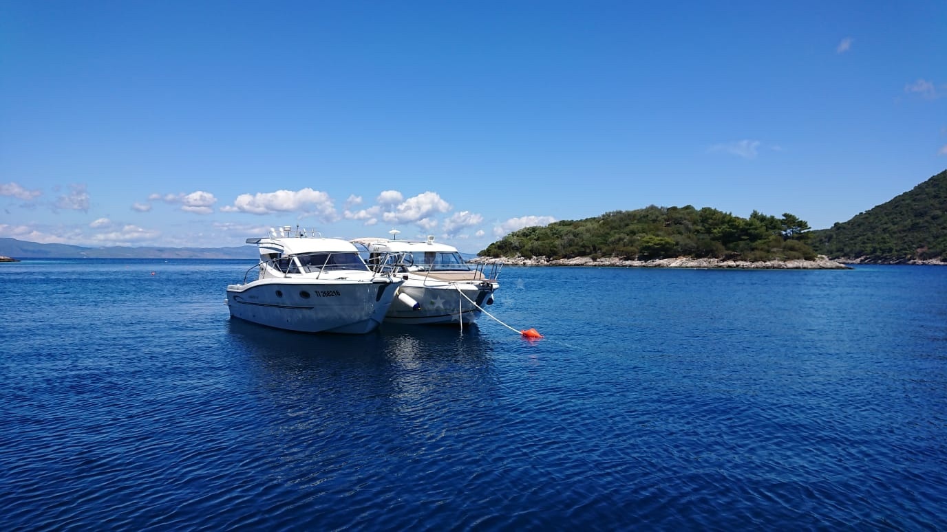 Konoba Mrcara buoy field with traditional Croatian architecture in the distance