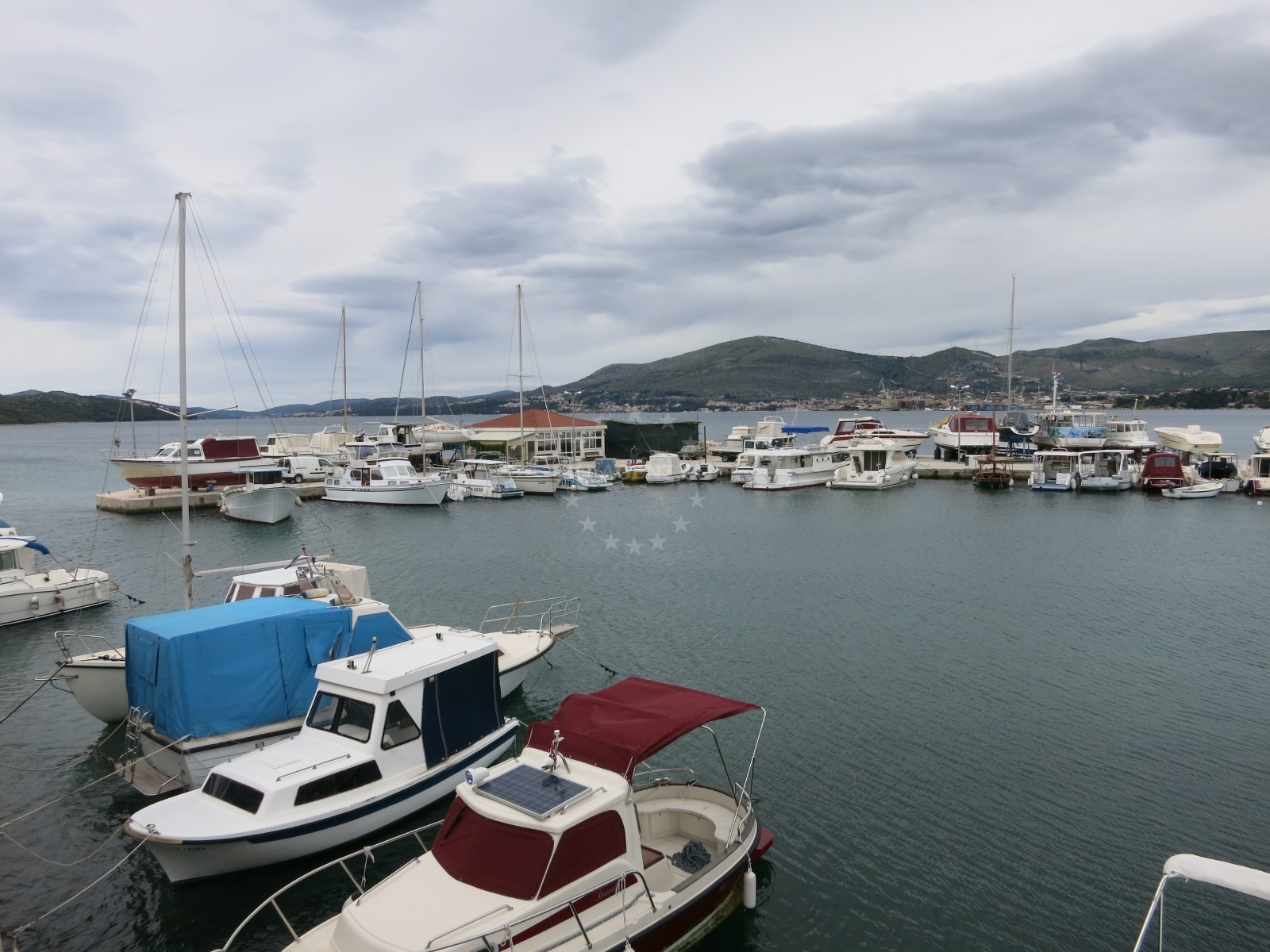 Toce Harbour in Okrug Gornji, Croatia, with local boats moored nearby.