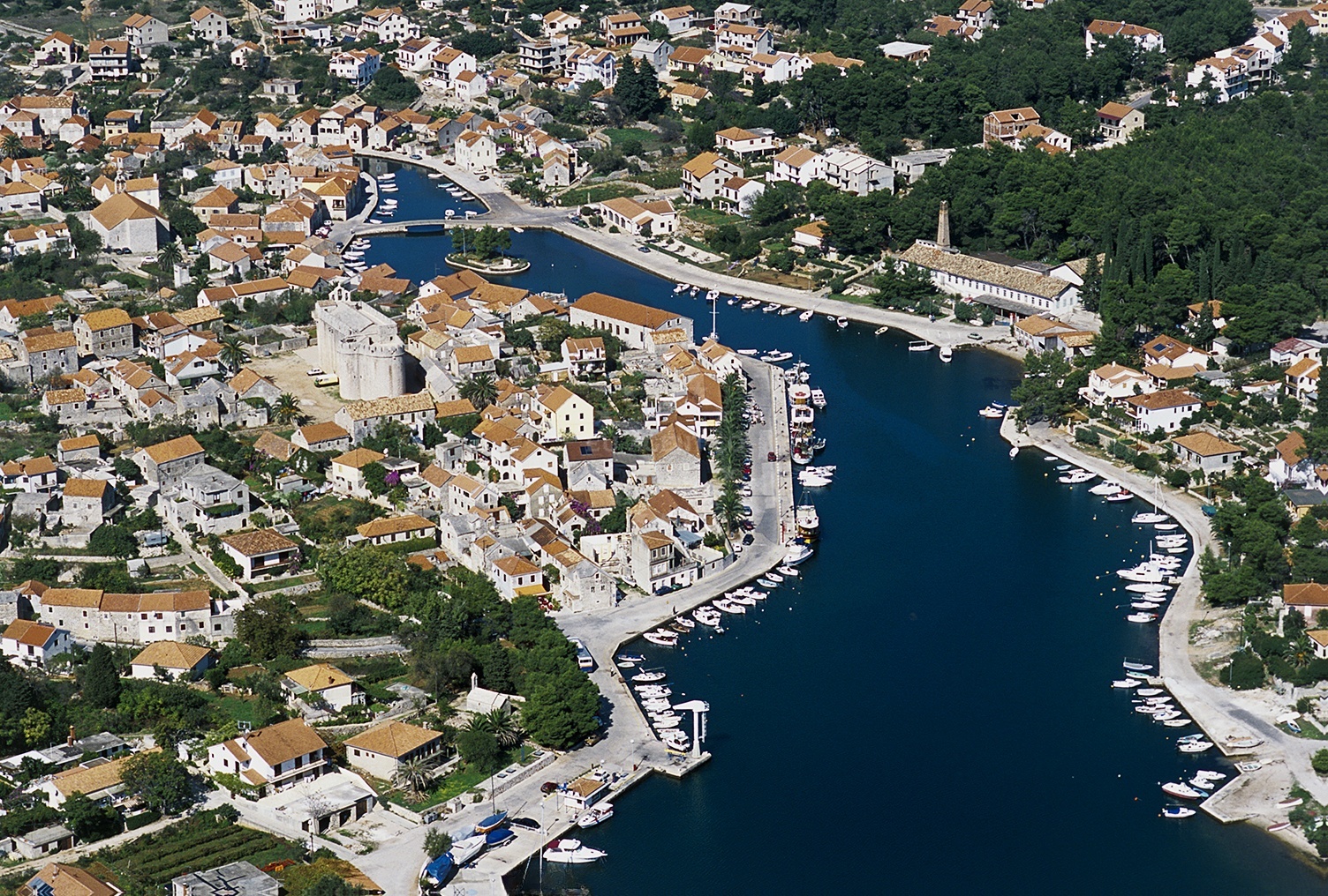 Vrboska Harbour quay with pine forest backdrop