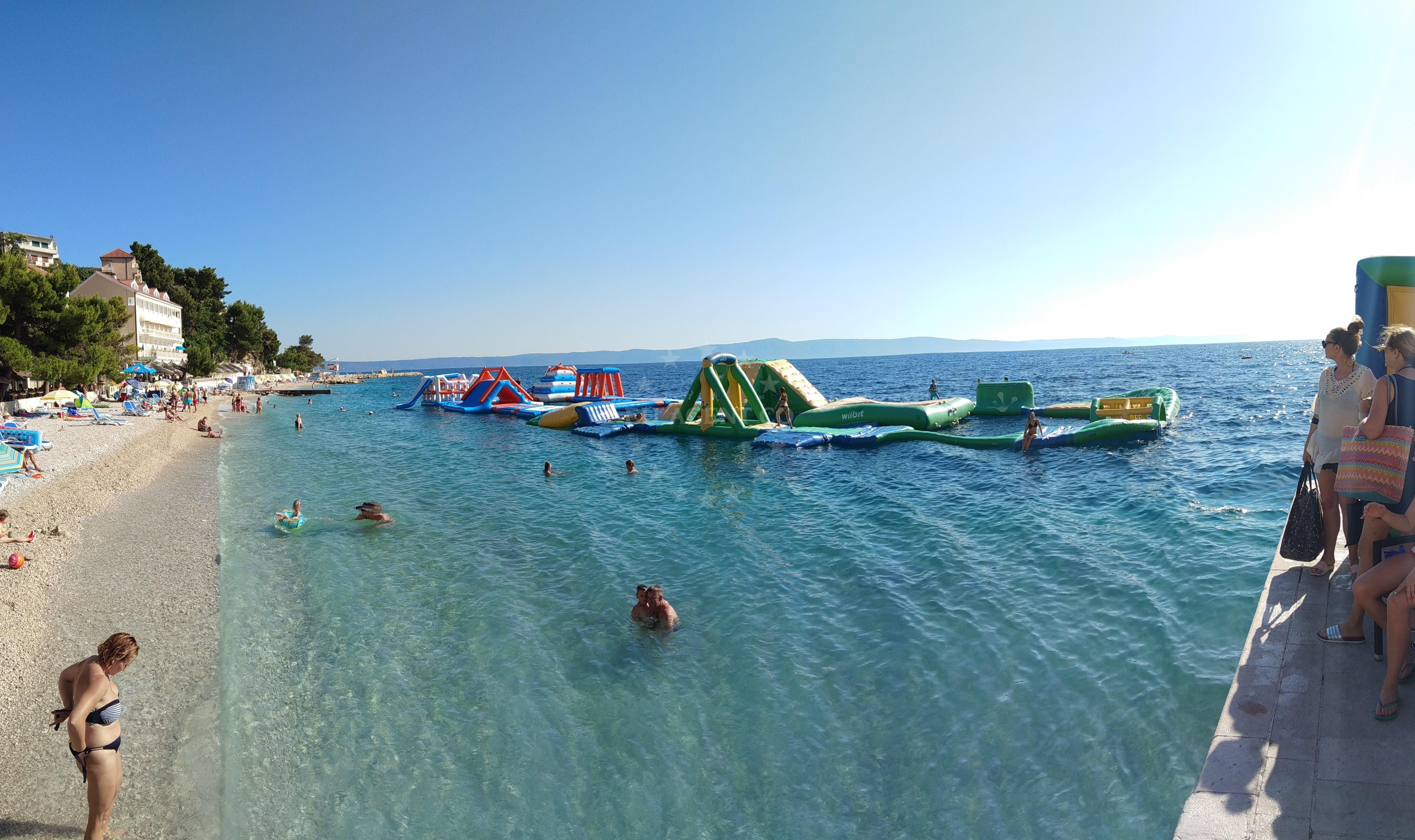 Traditional boat moored at Podgora Harbour with nearby viaduct
