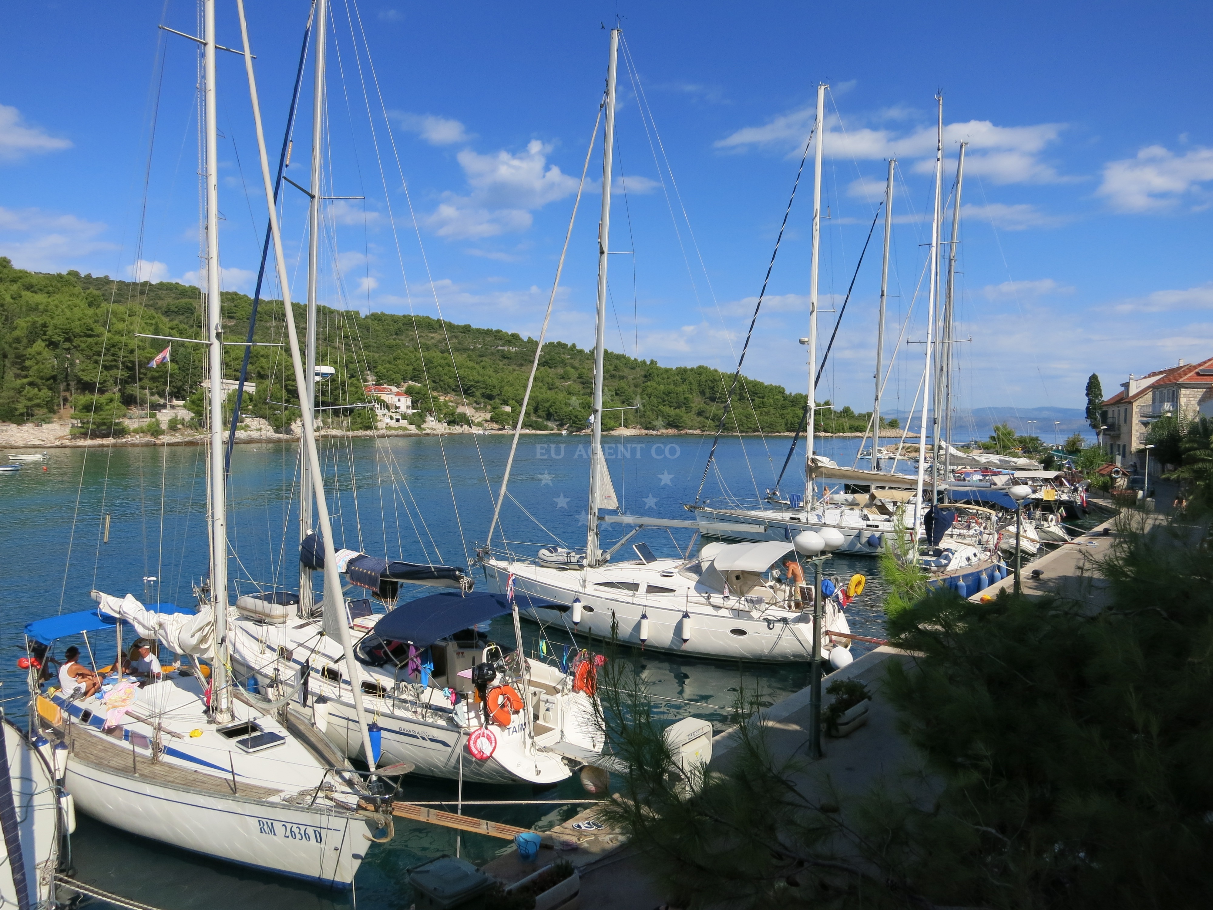 Stomorska Harbour, Šolta Island, Croatia - Sunset over the harbor with boats moored at the breakwater embankment.
