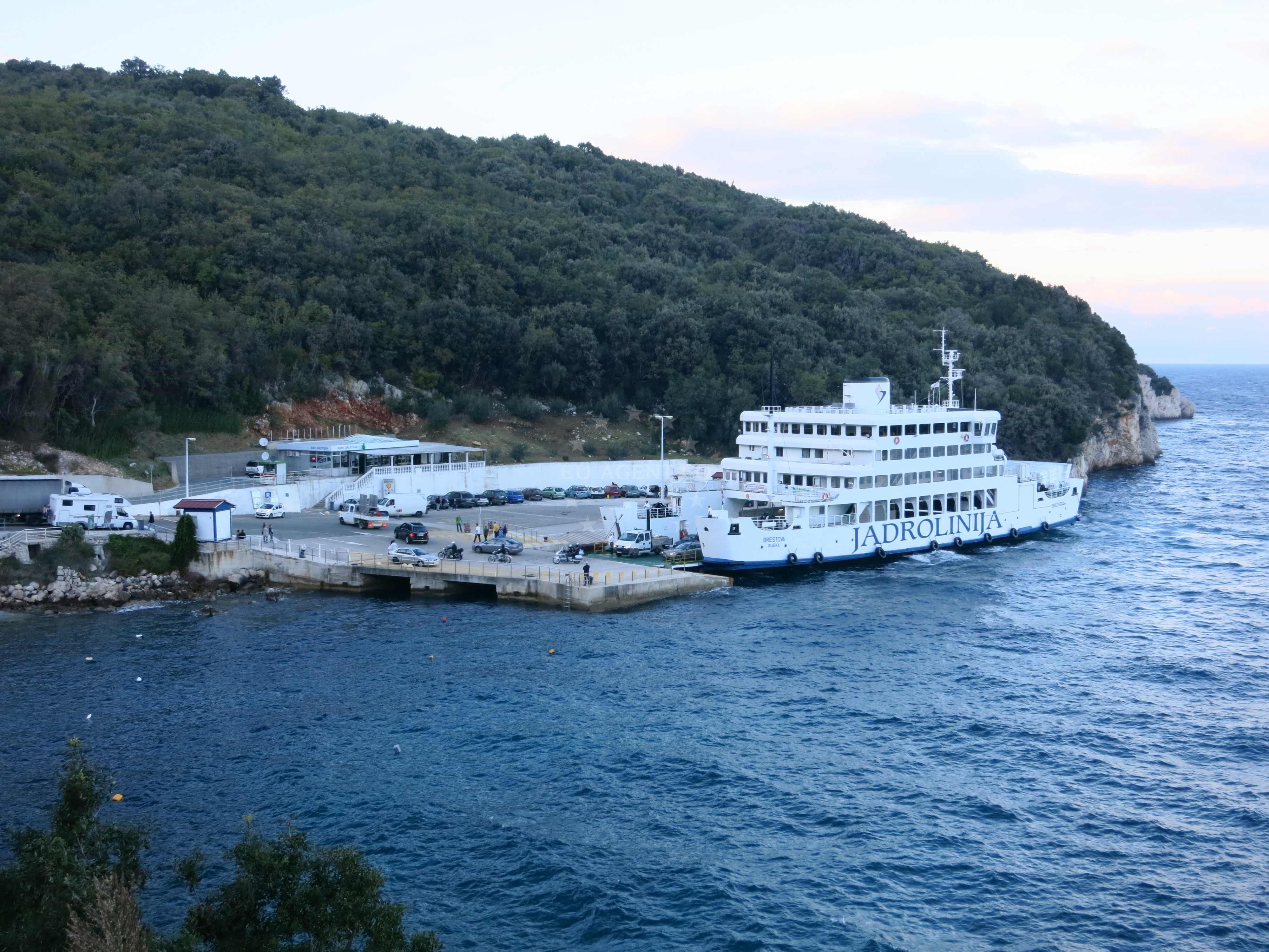 Brestova Beach, Croatia - straight shore with beige pebbles and mountainous terrain
