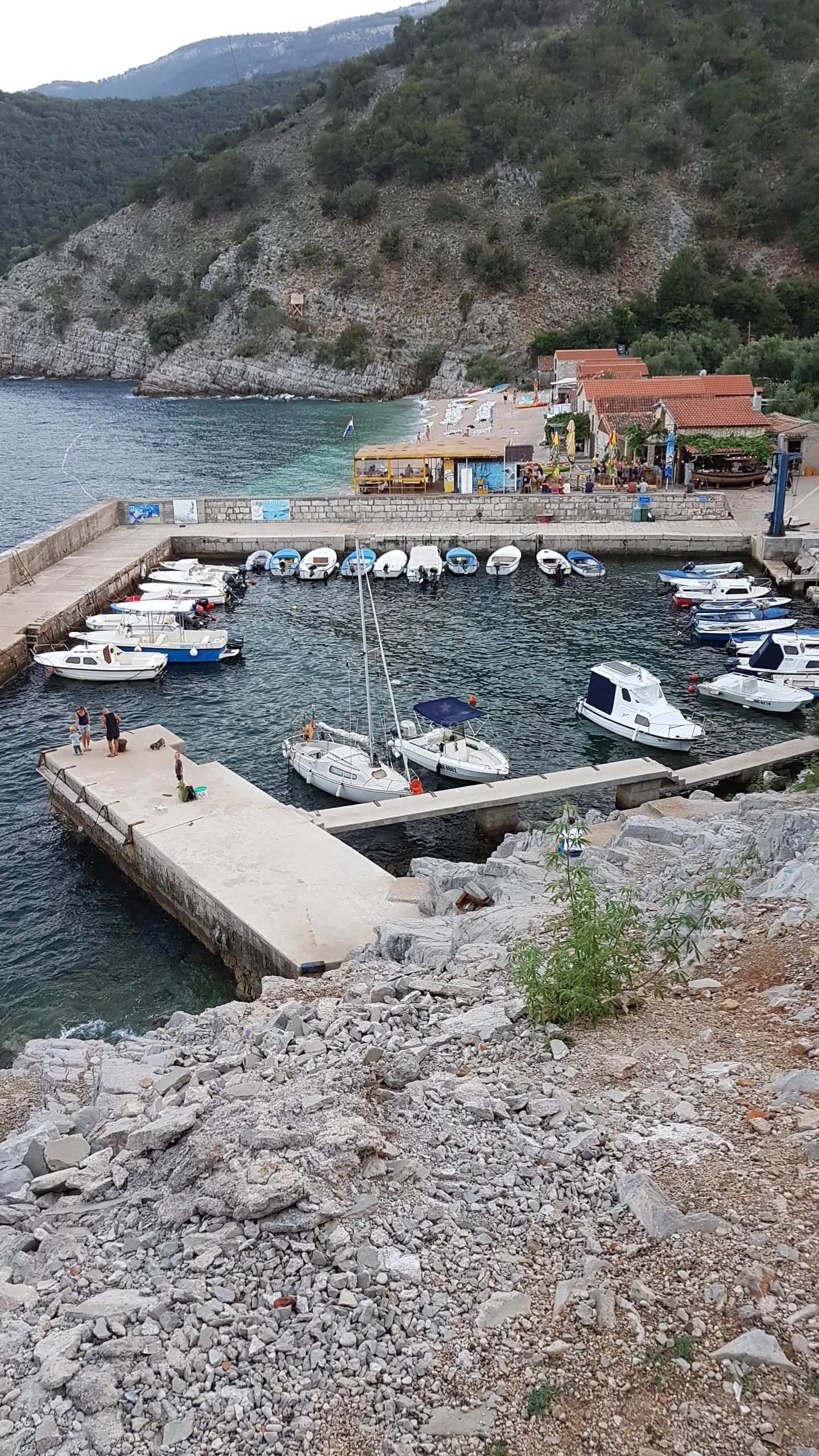 Beli Harbour on Cres Island, Croatia with white bell tower in the distance