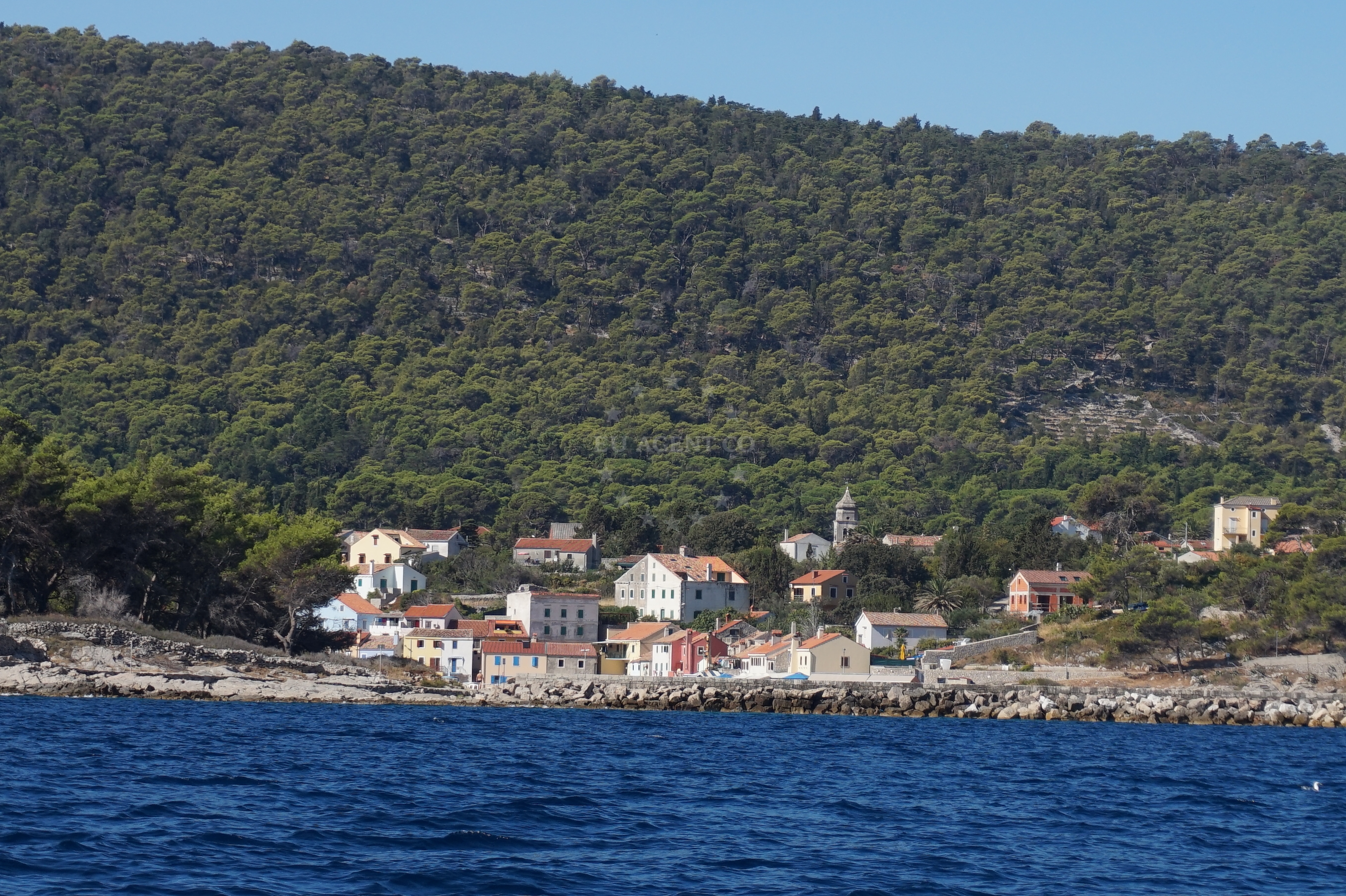 Rovenska Harbour, Veli Lošinj, Croatia - traditional breakwater with fishing boats and village houses