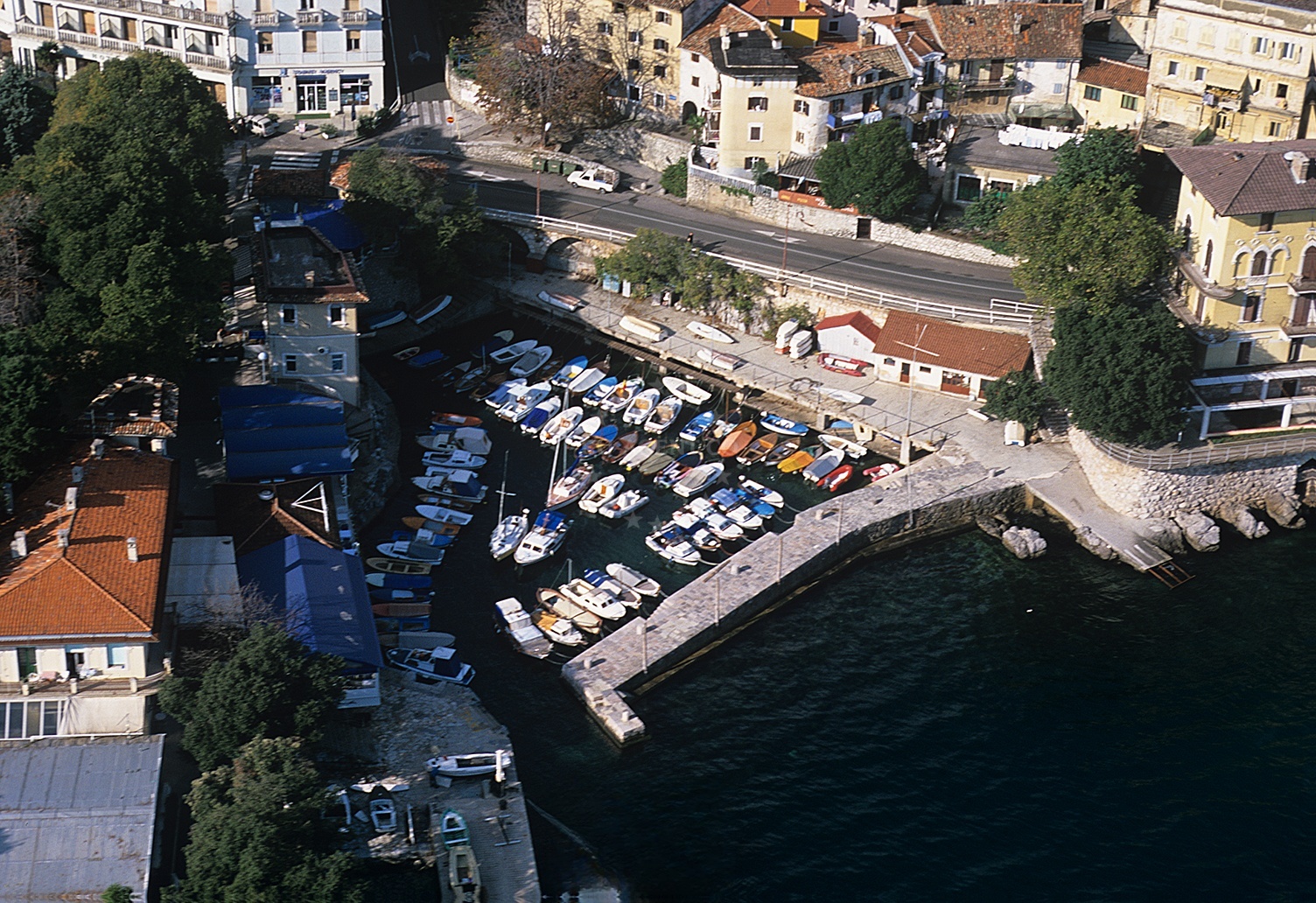 Lovran Harbour with historic bell tower and jetties