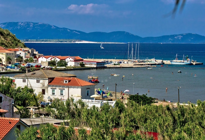 Susak Harbour entrance with limestone cliffs and moored yachts