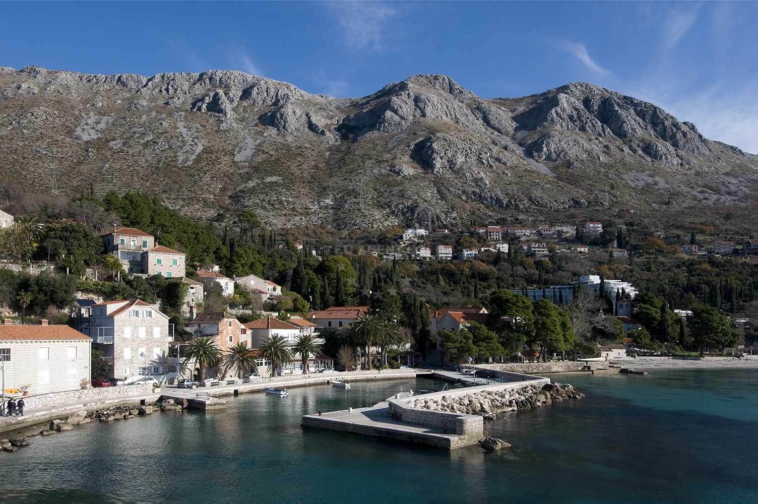 Mlini Harbour with village houses and a bell tower in the background