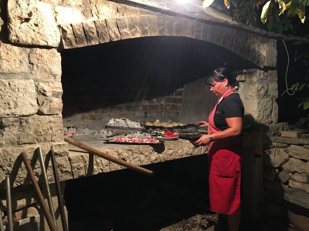 Traditional Croatian lamb peka being prepared on a stone hearth at Podhume Guesthouse