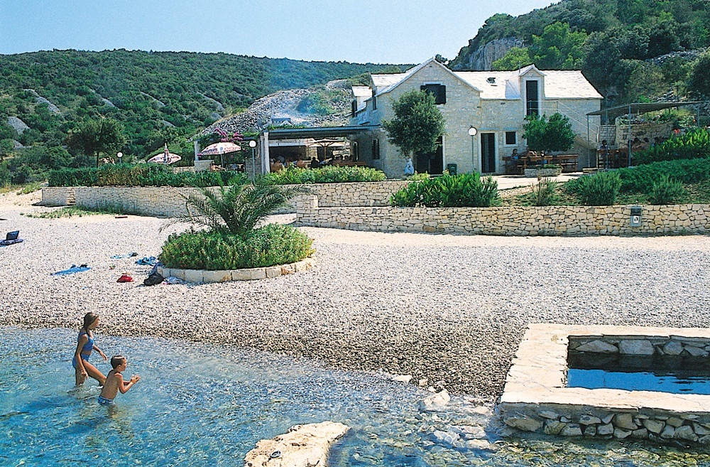 Hideaway Pipo Restaurant in Povlja, Brač, overlooking the Adriatic Sea with a pebble beach in the foreground