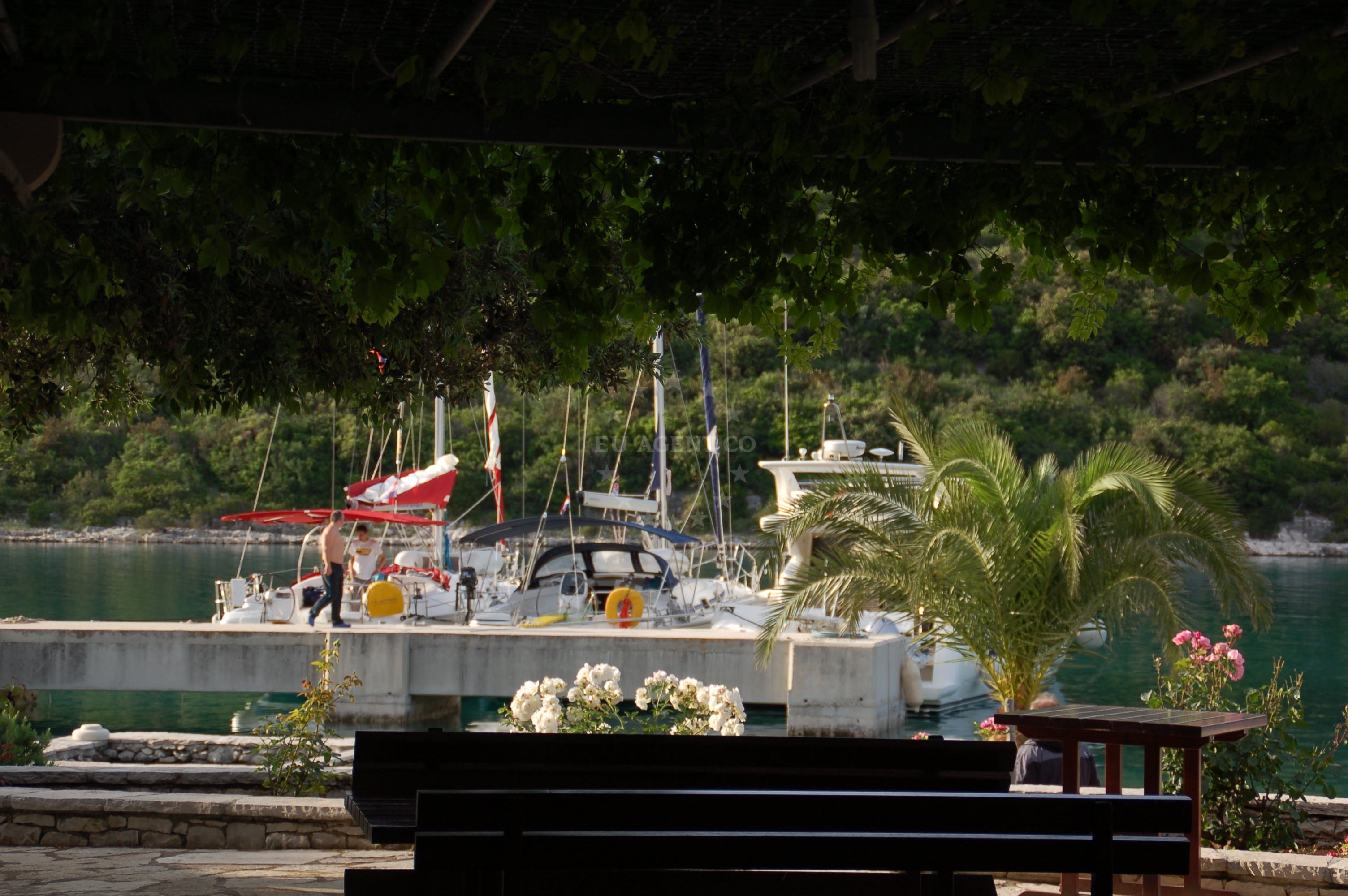 Pebble beach at Hideaway Pipo, Brač, with a yacht anchored nearby