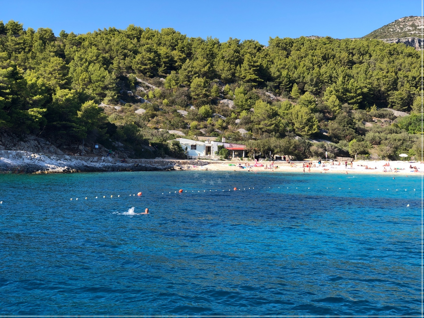 Restaurant in Hvar, Central Dalmatia, overlooking the Adriatic Sea with nearby Pokonji Dol beach visible in the distance.