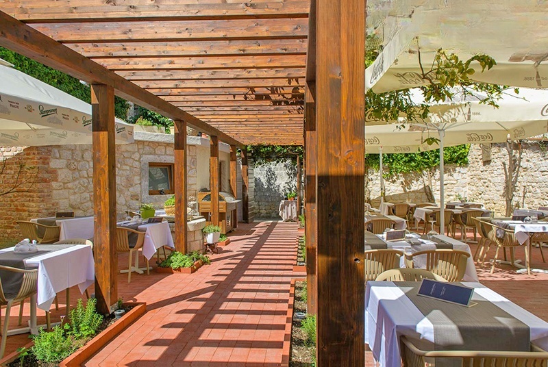 Private garden with stone house and wood grill