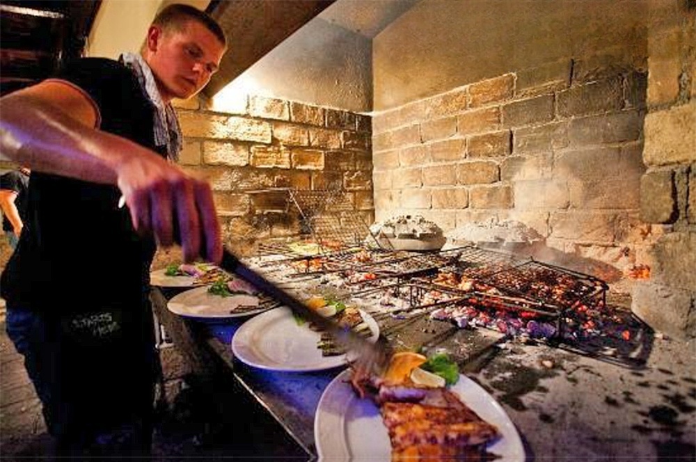 Interior of Barba Restaurant, Komiza, Vis, showcasing rustic decor and open-fire grilling