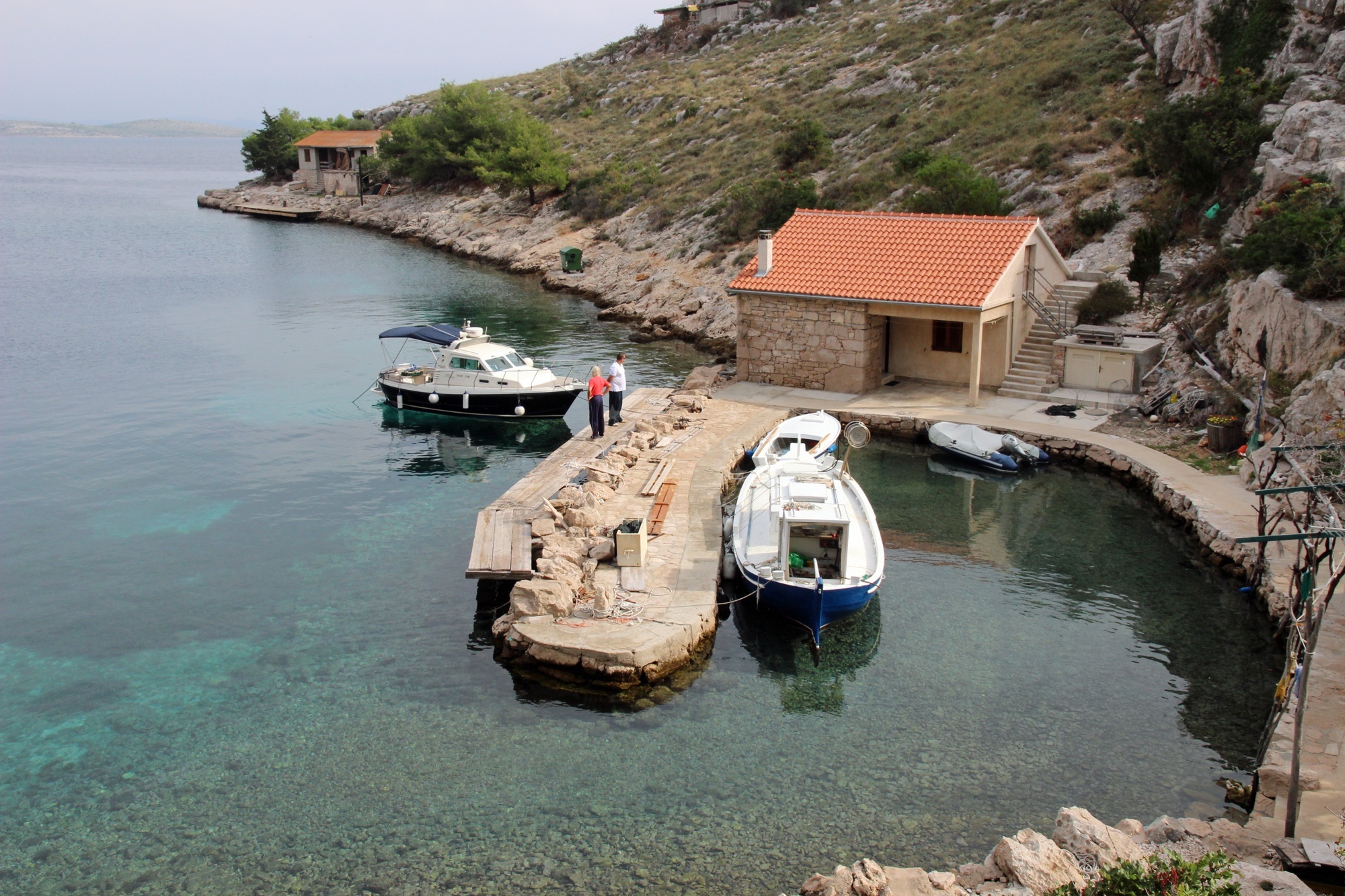 Boat approaching Stiniva Bay with the restaurant visible on the shoreline