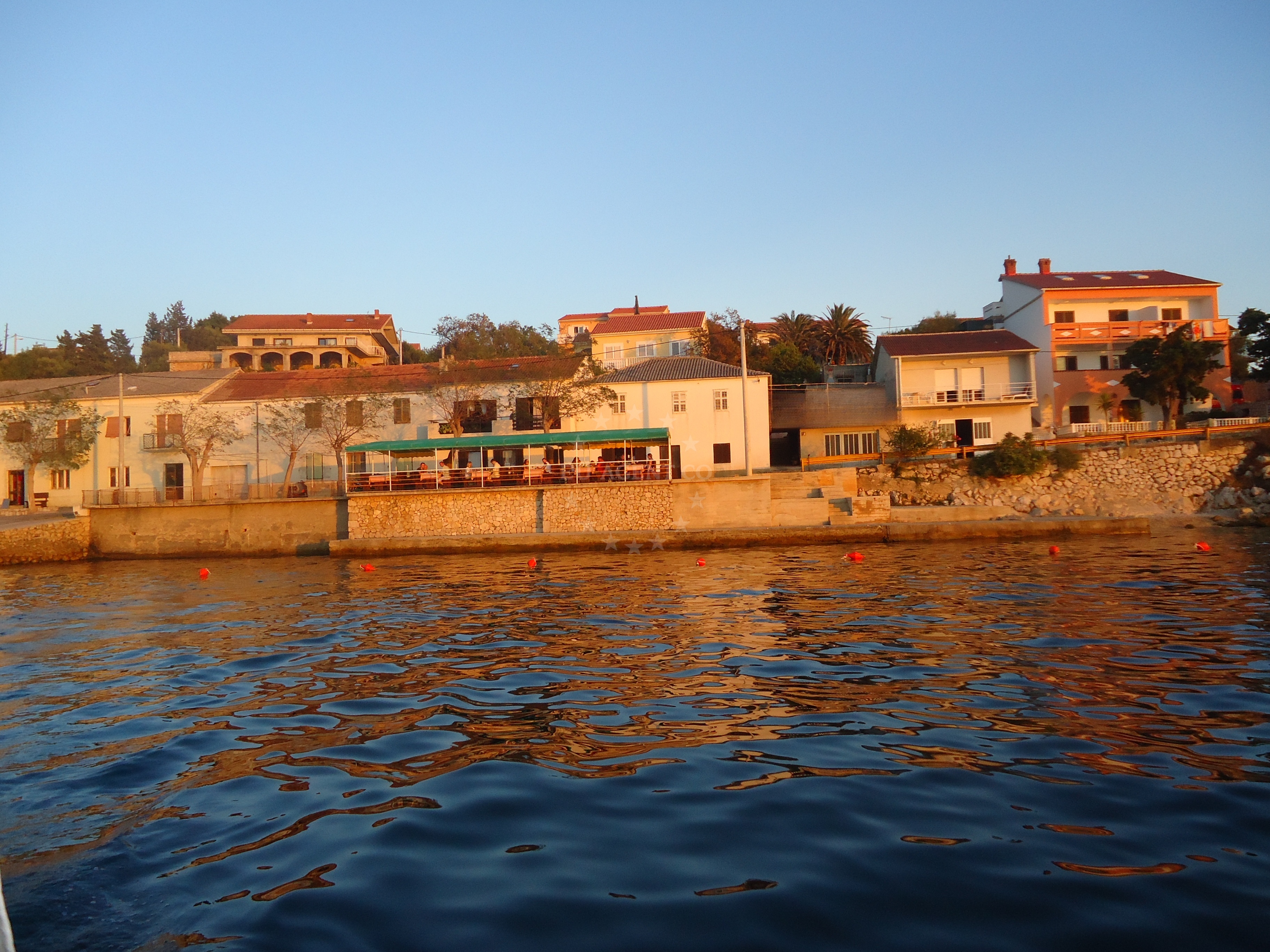 Jadran Restaurant in Tovarnele, Pag, overlooking the Adriatic Sea with a jetty in the foreground.